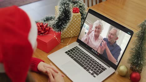 Caucasian-woman-on-video-call-with-grandparents-at-christmas-time