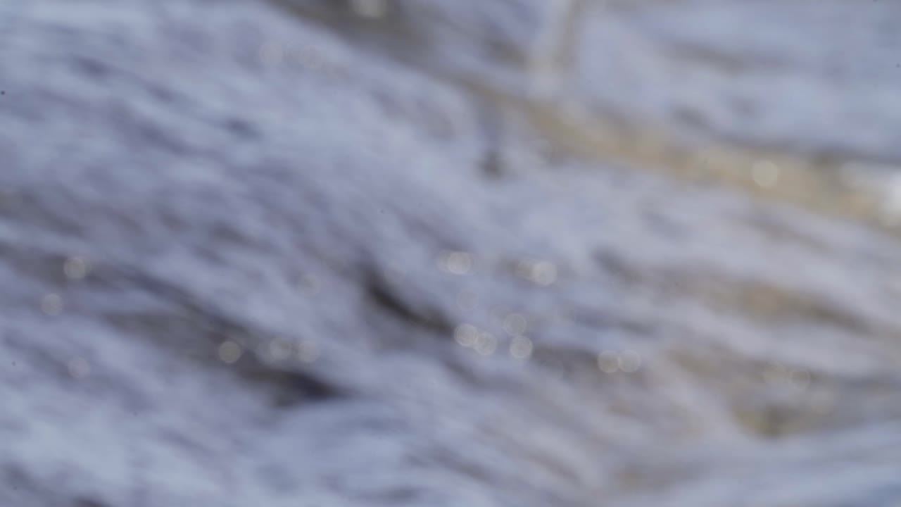 fuera de foco olas bokeh rompen en una orilla rocosa