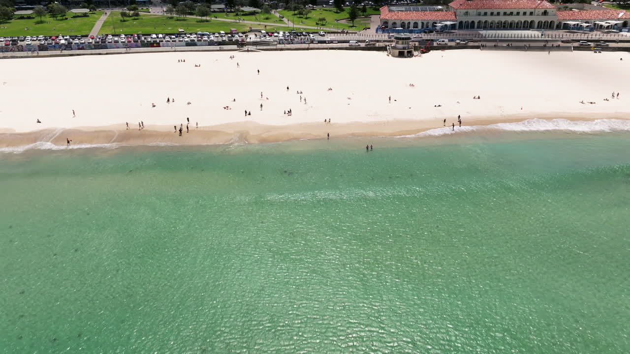 여름날을 즐기는 사람들과 상징적인 본다이 해변의 아름다운 청록색 물