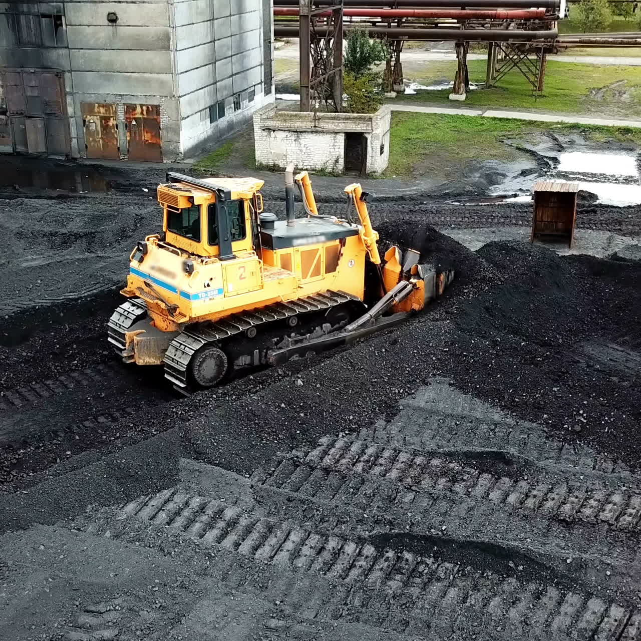 Crawler bulldozer sorts coal. Industry. Aerial view.