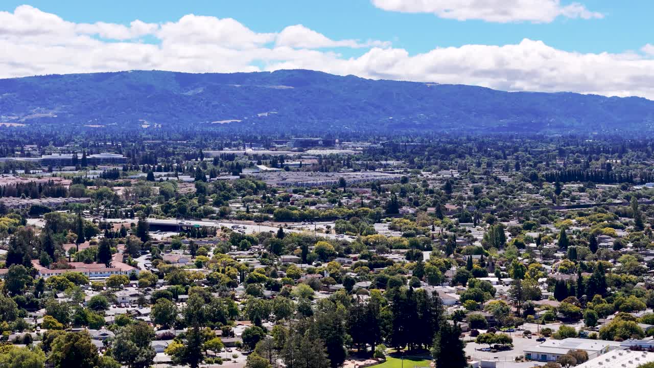 캘리포니아의 실리콘 리 (silicon valley) 의 한 교외 지역, 푸른 하늘 아래 울창한 초록색과 멀리 떨어진 산맥의 공중 풍경