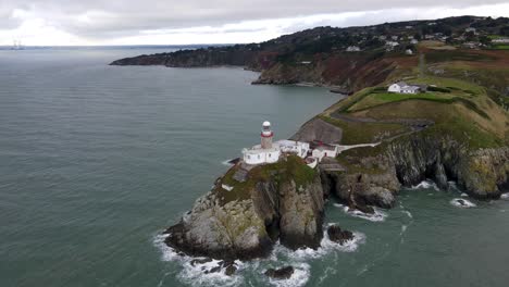 drone shot of a small lighthouse on a cliff near dublin