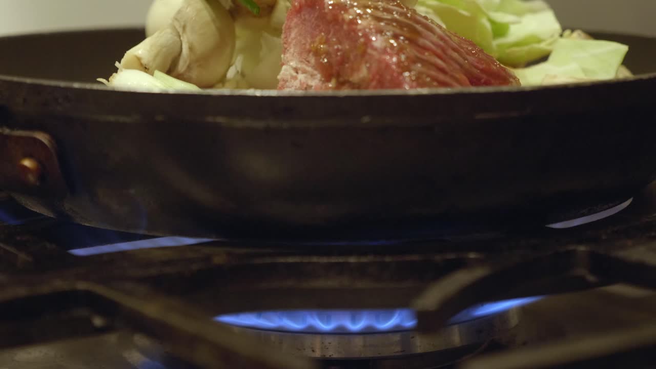 Cucinare un piatto coreano salutare con verdure in padella su fornello a gas
