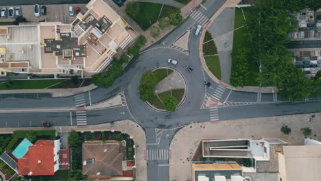 automobiles riding ring road in small city top view. round traffic at cozy town