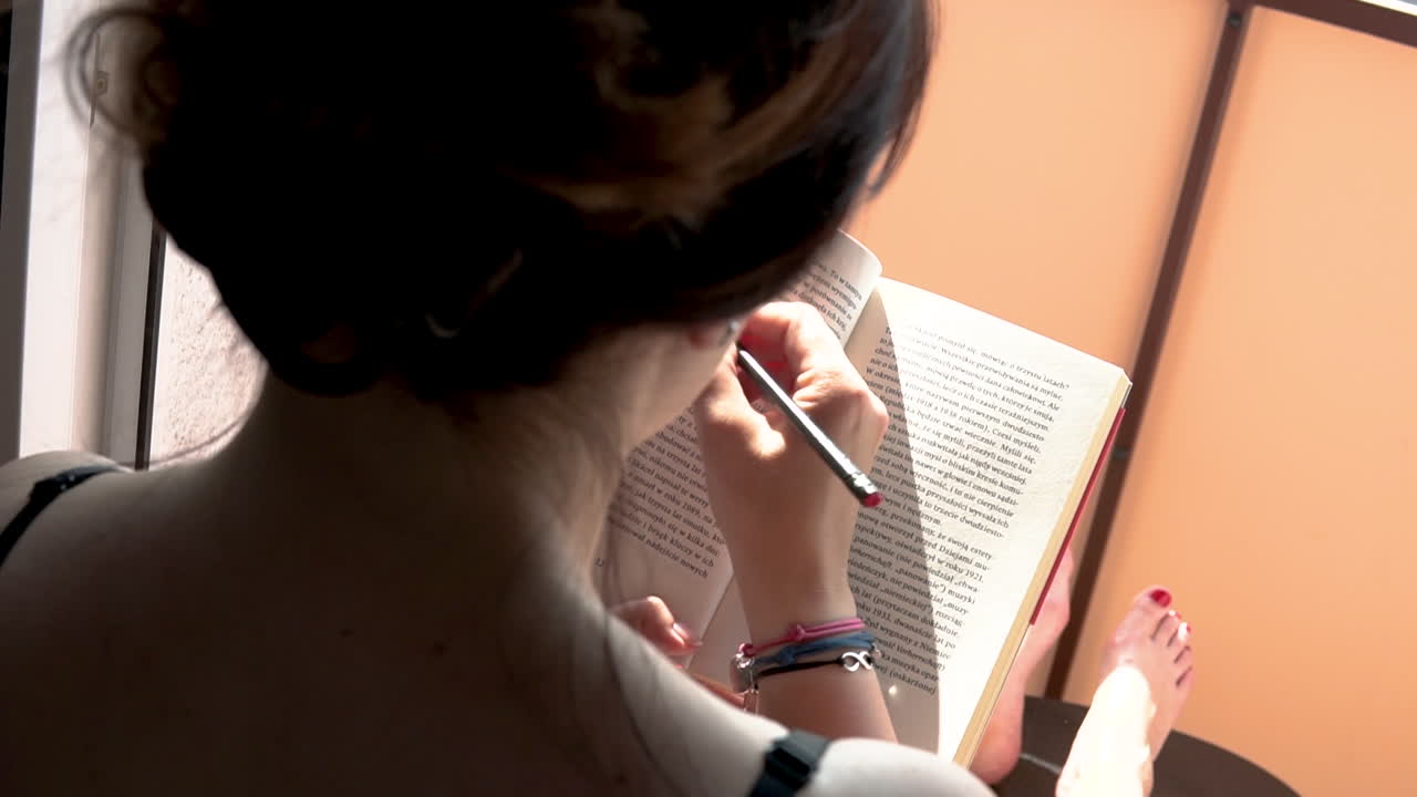 The girl is sitting on the balcony with her legs on the table