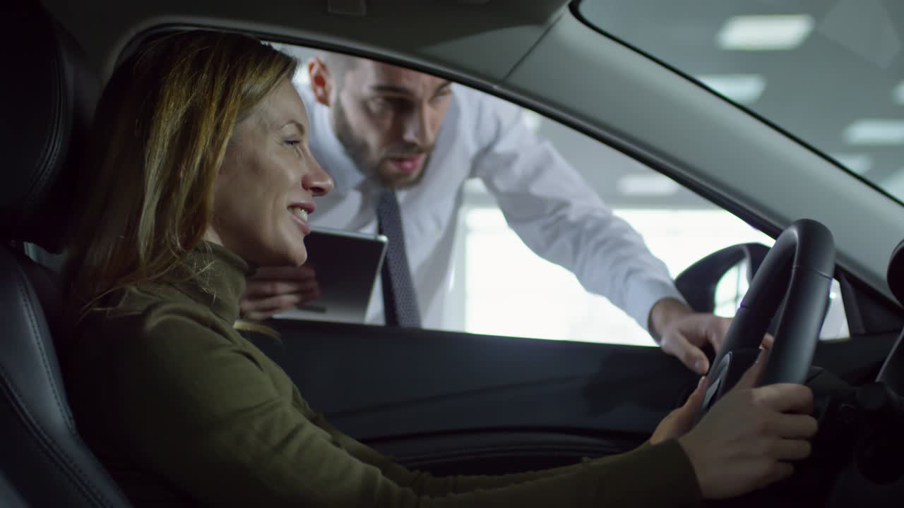 mujer feliz eligiendo un coche en el concesionario