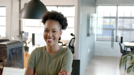 young african american businesswoman smiles confidently in a bright office with copy space