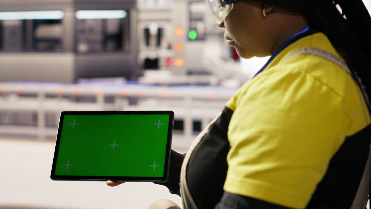 Vertical video Industrial plant technician uses isolated screen tablet