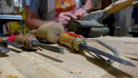 italian sculptor in his workshop working on a olive wood statue