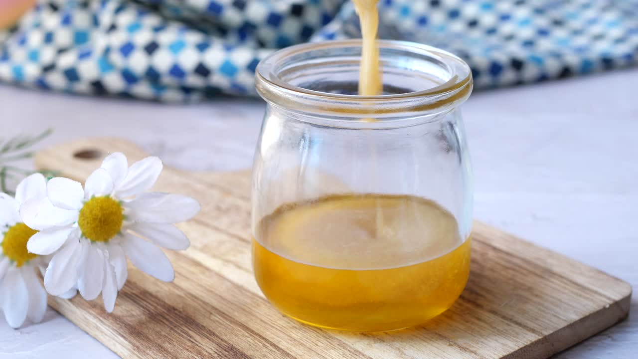 Condimento fatto in casa al miele e limone versato in un barattolo di vetro