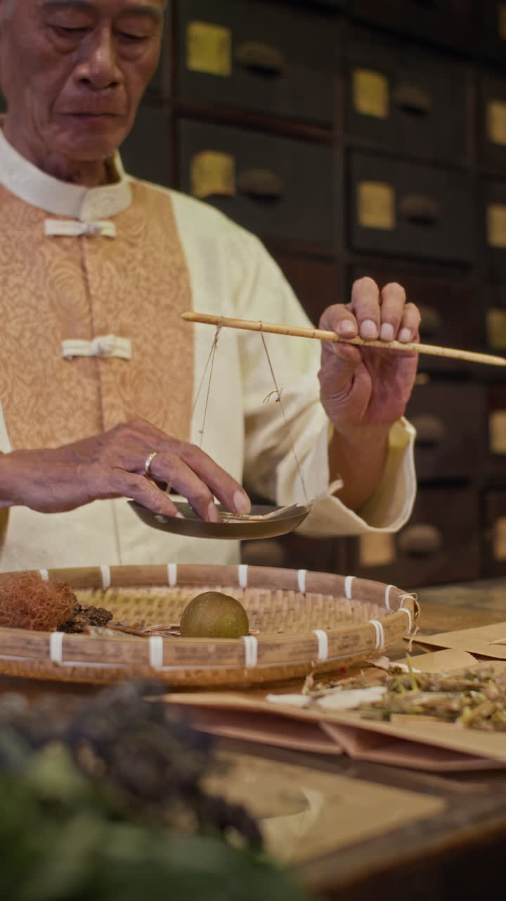 Asian Man Weighing Ingredients for Mixture Using Scales at Herbal Pharmacy