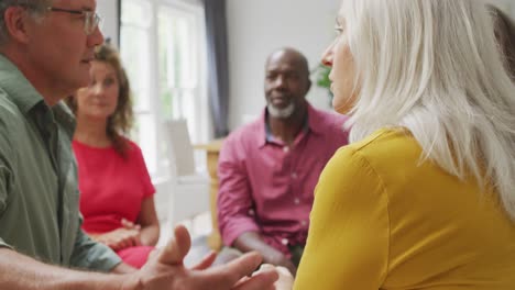 Animation-of-caucasia-female-and-male-seniors-embracing-during-support-group-meeting