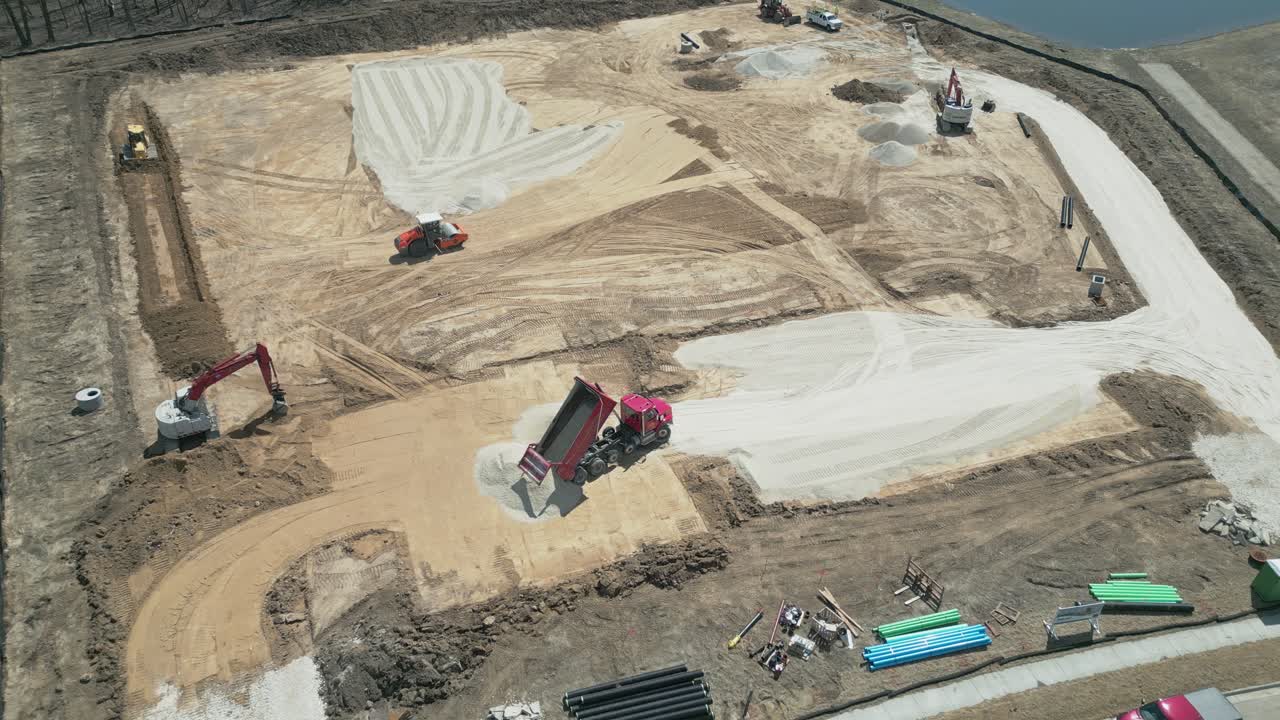 Aerial birds eye view of construction trucks laying out the foundational groundwork for a new construction site in the (up and coming area) of Ozaukee County, Milwaukee, Wisconsin