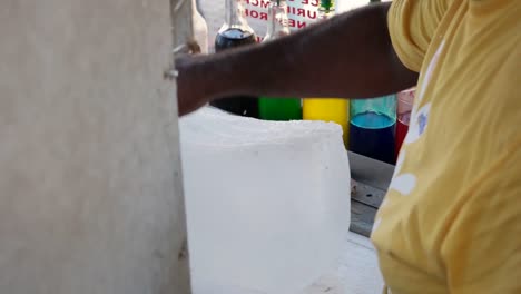 a person making "piraguas" shaved ice in the street