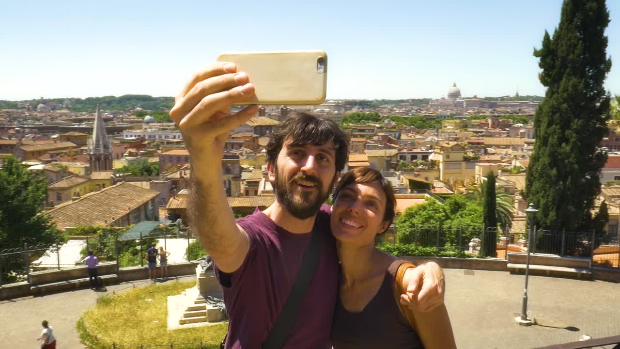 una pareja joven tomando una selfie con el paisaje urbano de roma.
