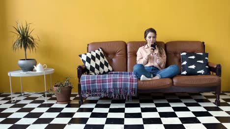 woman relaxing on a couch and using a smartphone