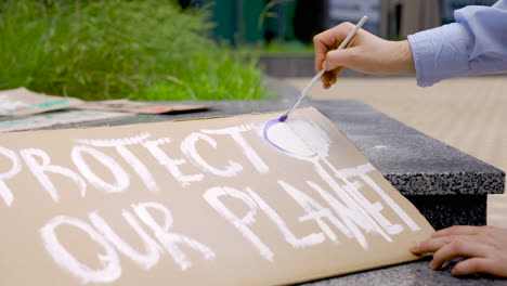 close up of hands painting a placard