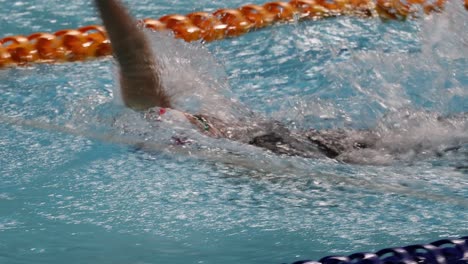 swimmer racing through water in a pool