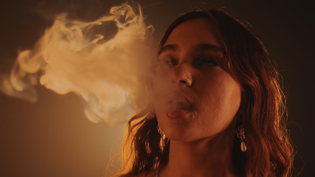 Woman Smoking Vape in Yellow Light Room