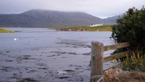 Shot-of-a-sea-loch-with-a-highland-mountain-covered-in-cloud-in-the-distance