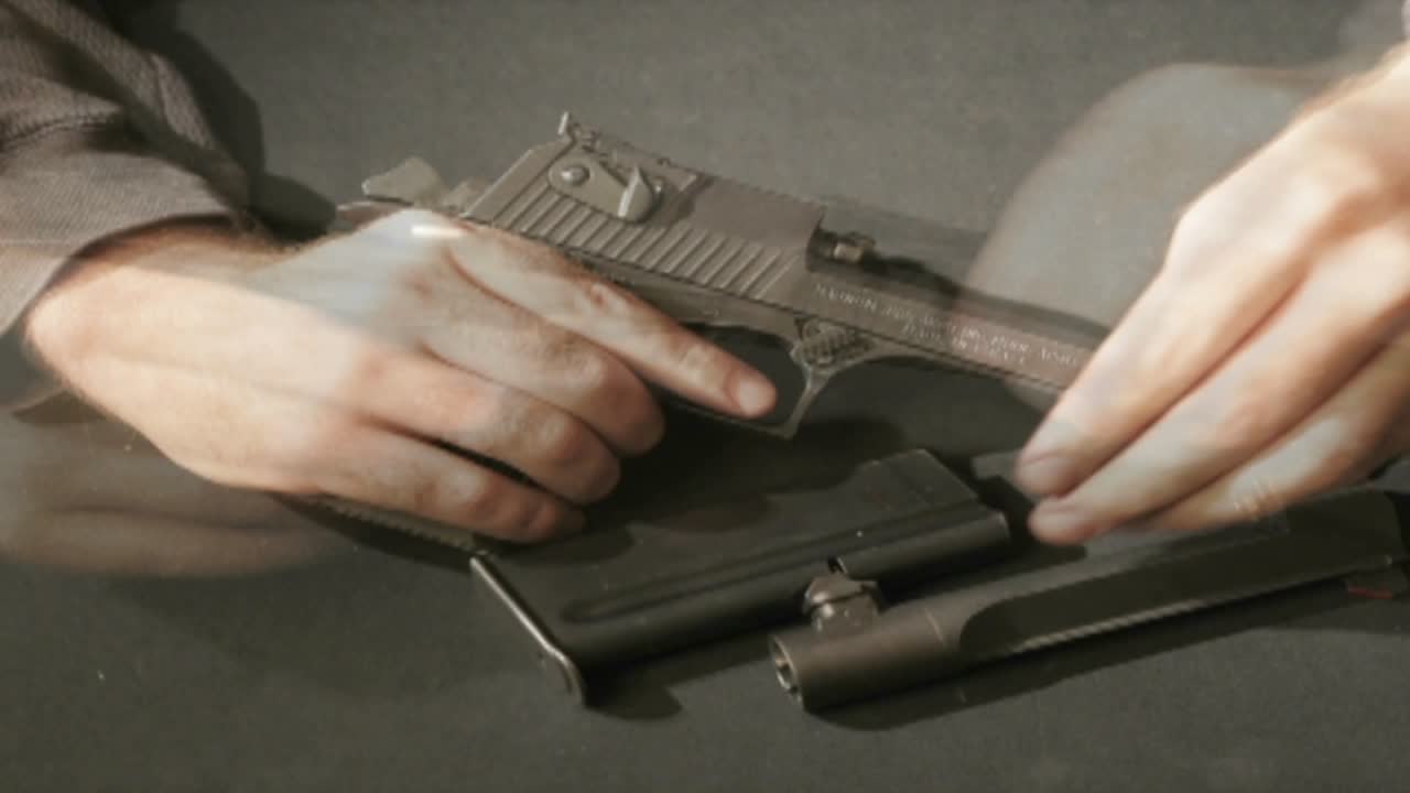 A time lapse shot of a man assembling and disassembling a gun potential used for terror
