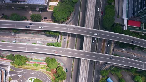 Aerial-View-Of-Cars-Driving-In-The-Overpass-And-Street-On-A-Sunny-Day-In-Jakarta,-Indonesia