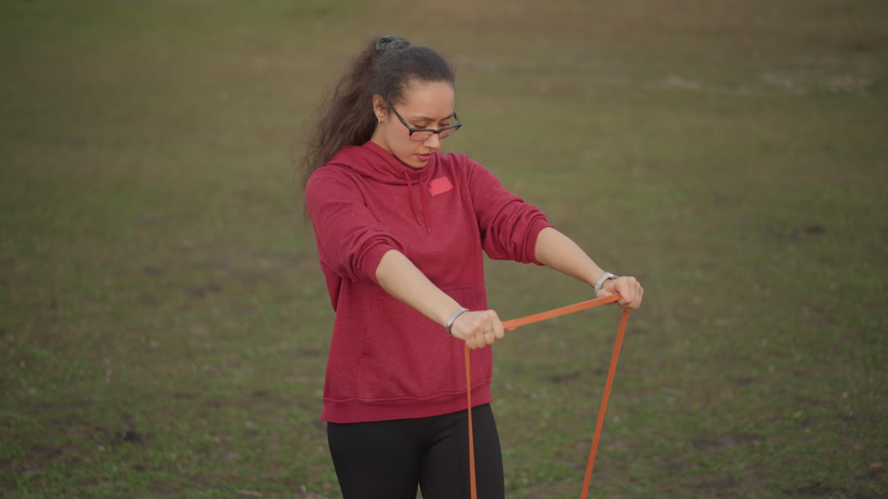 Influencer Showcasing Resistance Band Exercises With Proper Form Outdoors, Outdoor Location Video Of Influencer Demonstrating Resistance Band Workout Techniques With Emphasis On Form And Posture