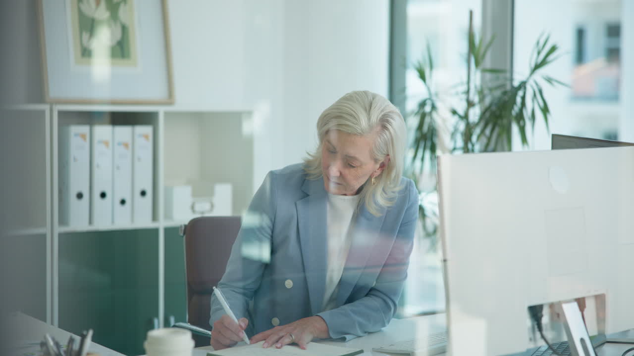 Mature Businesswoman Working and Writing in a Modern Office
