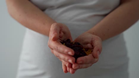 female hands in heart shape showing blueberries and raisins. close up