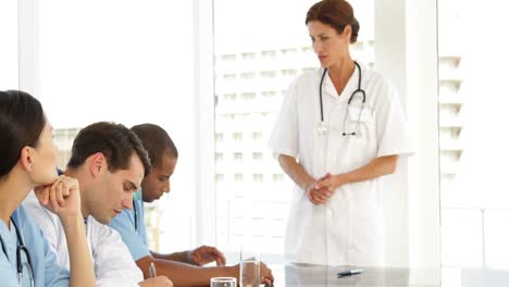 doctora hablando con su personal durante una reunión.