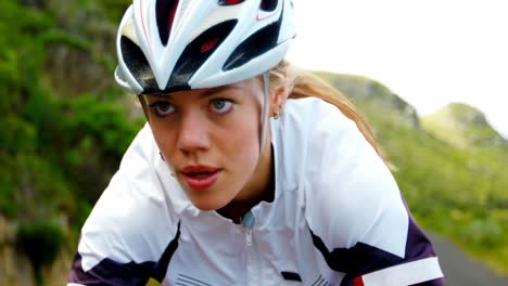 female cyclist cycling on a countryside road 4k