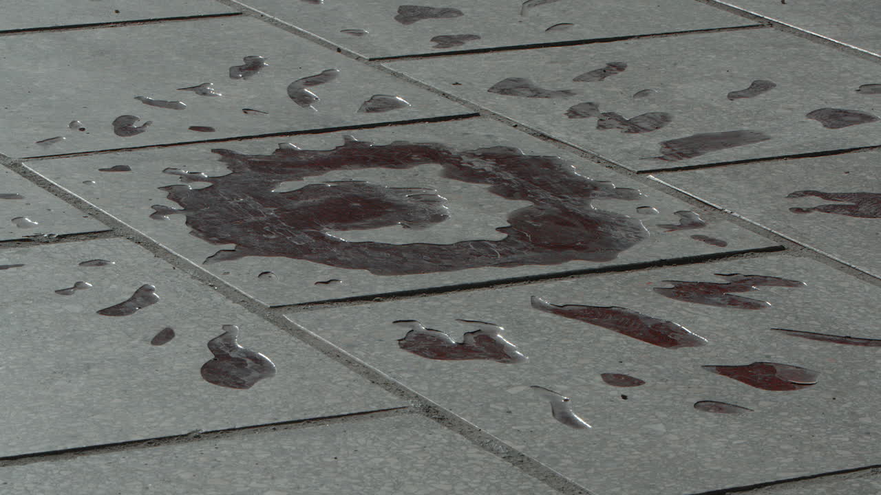 Close up view of man walking over Sarajevo rose, a war memorial on the street indicating where three or more people were killed during the siege of Sarajevo, Bosnia.