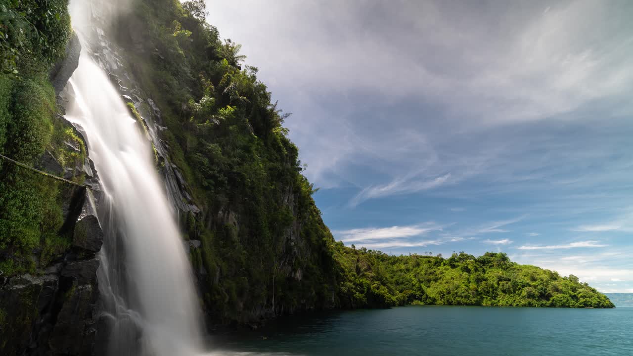 Majestuosa cascada cayendo en aguas azules