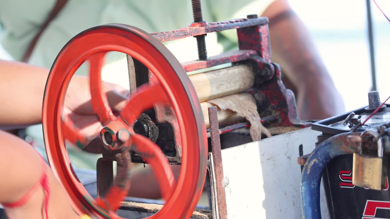 길거리 판매자가 수동으로 건조한 오징어를 압축하고 있습니다.