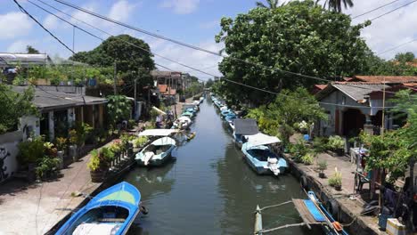 Looking-down-polluted-river-with-small-huts-and-fishing-boats-in-Negombo,-Sri-Lanka