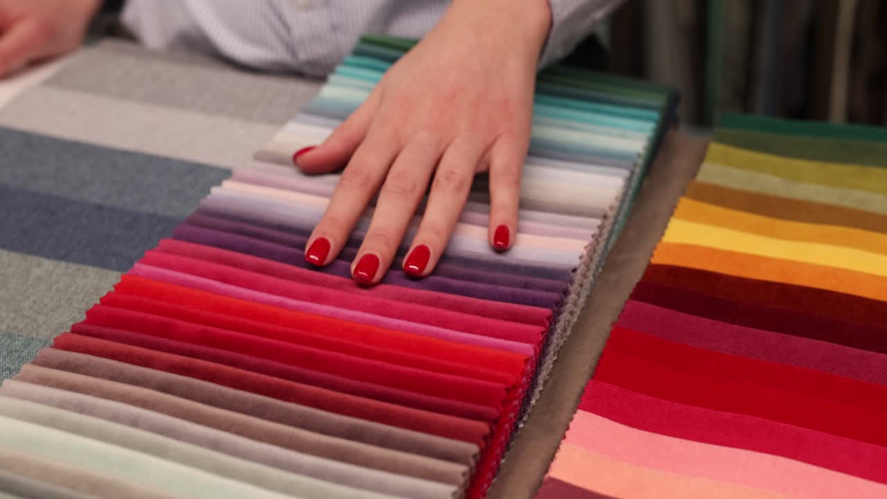 Hand touching colorful fabric swatches