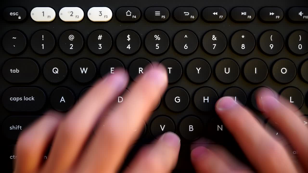 Close-up of Hands Typing on a Round-Key Black Keyboard