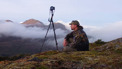un fotógrafo de naturaleza y vida silvestre en las montañas de la isla de kodiak, alaska, preparándose para una sesión de fotos en la naturaleza
