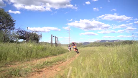 offroad dirt bike riders racing around a corner at full speed