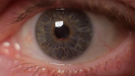 close up of eye looking at flashing red light