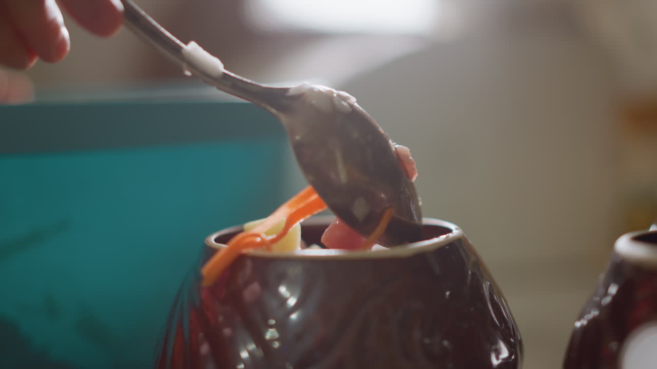 Caucasian hands spooning vegetable stew into clay pot, closeup ladle movement captures carrot strands and broth, soft backlight and morning light, slow deliberate homestyle cooking ritual with cozy