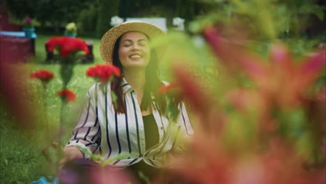 woman in straw hat enjoying tranquility in a garden surrounded by vibrant flowers and greenery