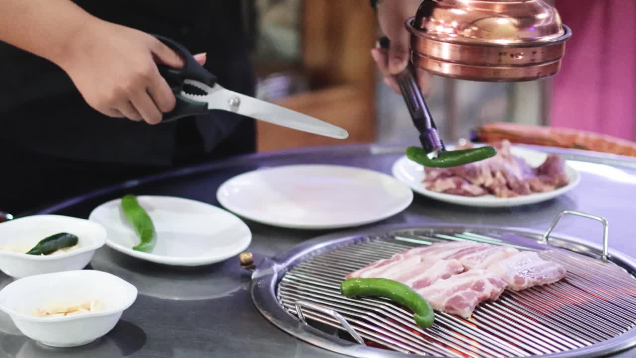 셰프는 전문적으로 고기와 채소를 그릴로 준비합니다.