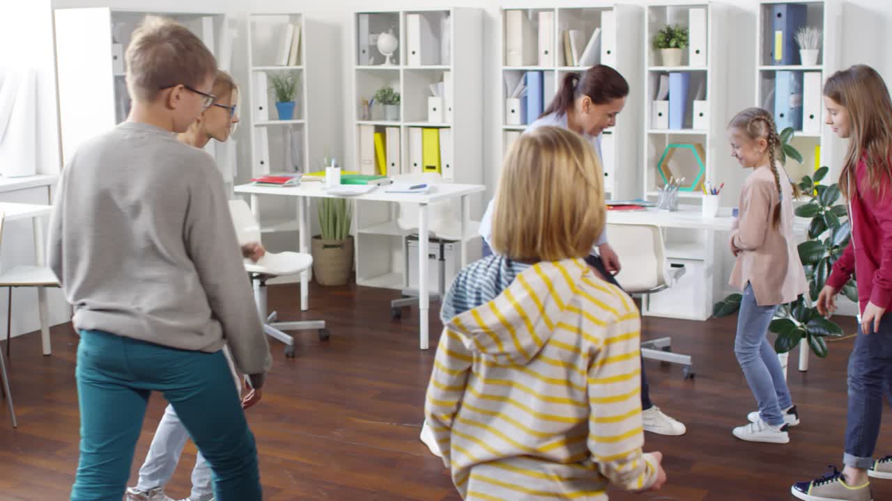 шесть подростков и женщина играют в игру в школьном офисе