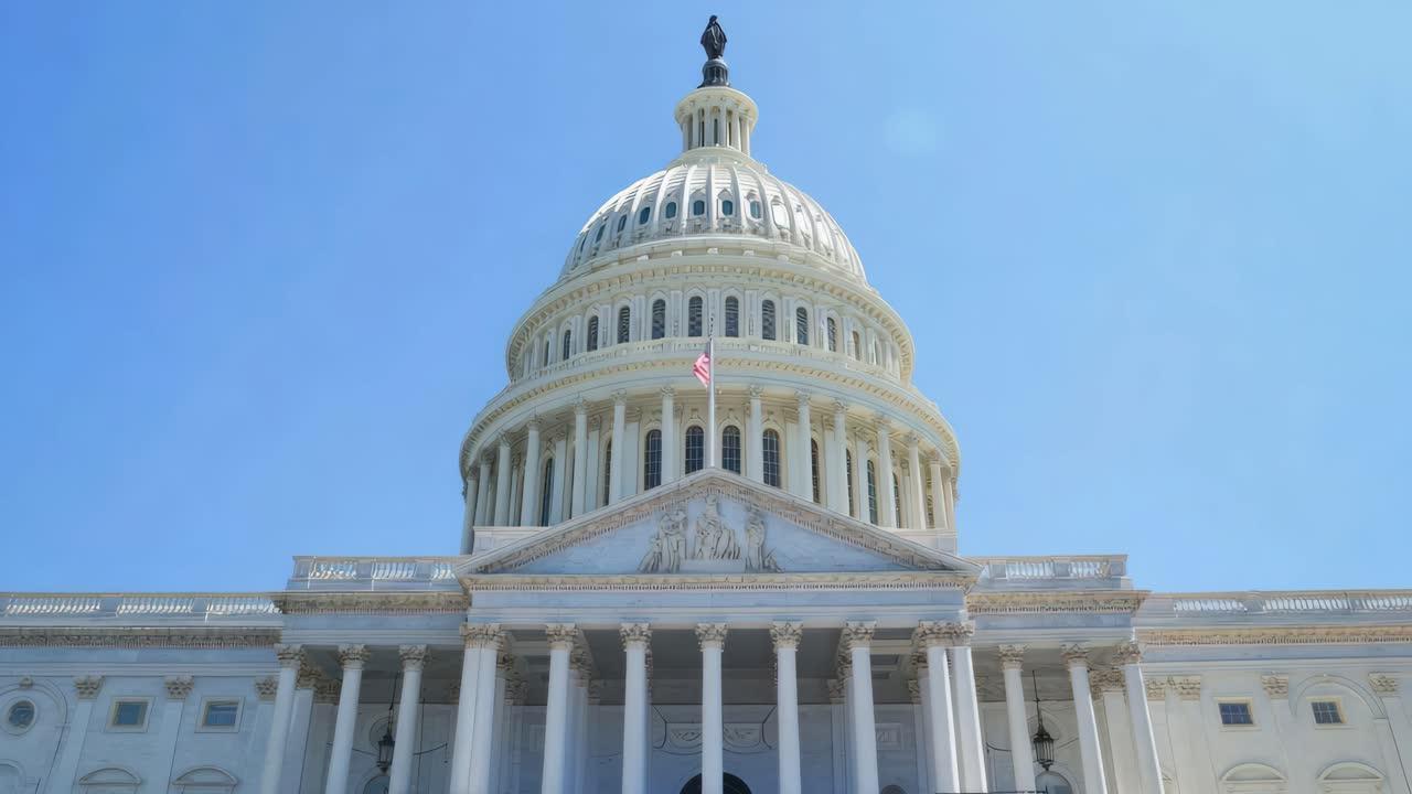 A low-angle video shot of the Capitol building under a clear blue sky, highlighting its grandeur