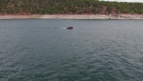 Hombre-Montando-Waverunner-Jet-Ski-Sea-Doo-En-El-Embalse-Del-Lago-Flaming-Gorge,-Antena