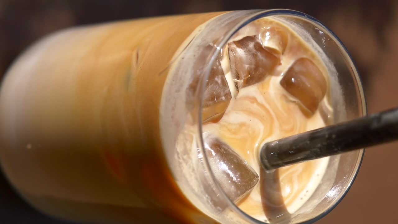 Primer plano de café helado con crema arremolinada y hielo