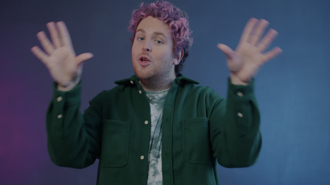 Man with Pink Hair Making a Heart Shape with Hands