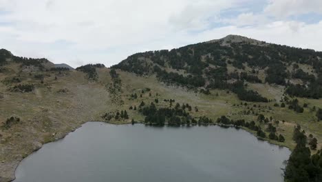 Vista-Aérea-Moviéndose-Del-Lago-A-Las-Montañas