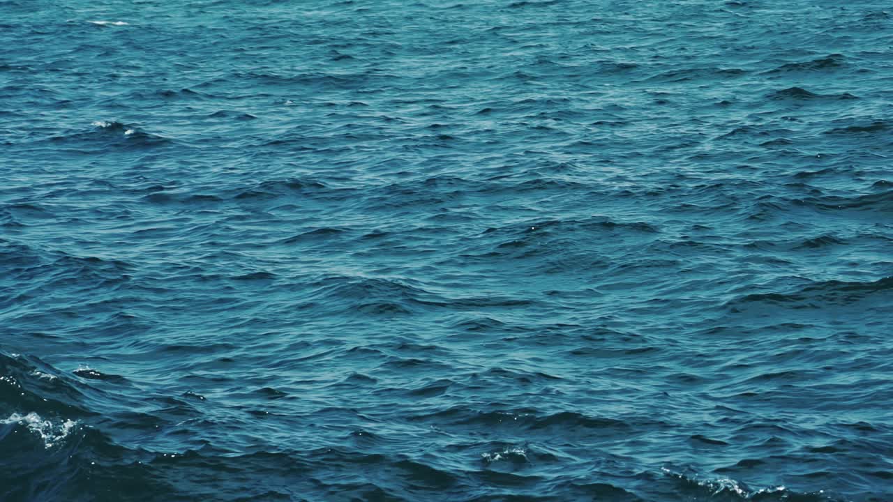 Blue sea surface. Background texture of a calm deep blue ocean with ripples on the surface of the sea water